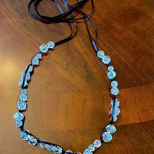 Clear beaded necklace with black ribbon intertwined.